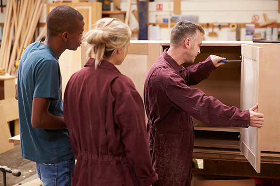 Apprentices assembling cabinet