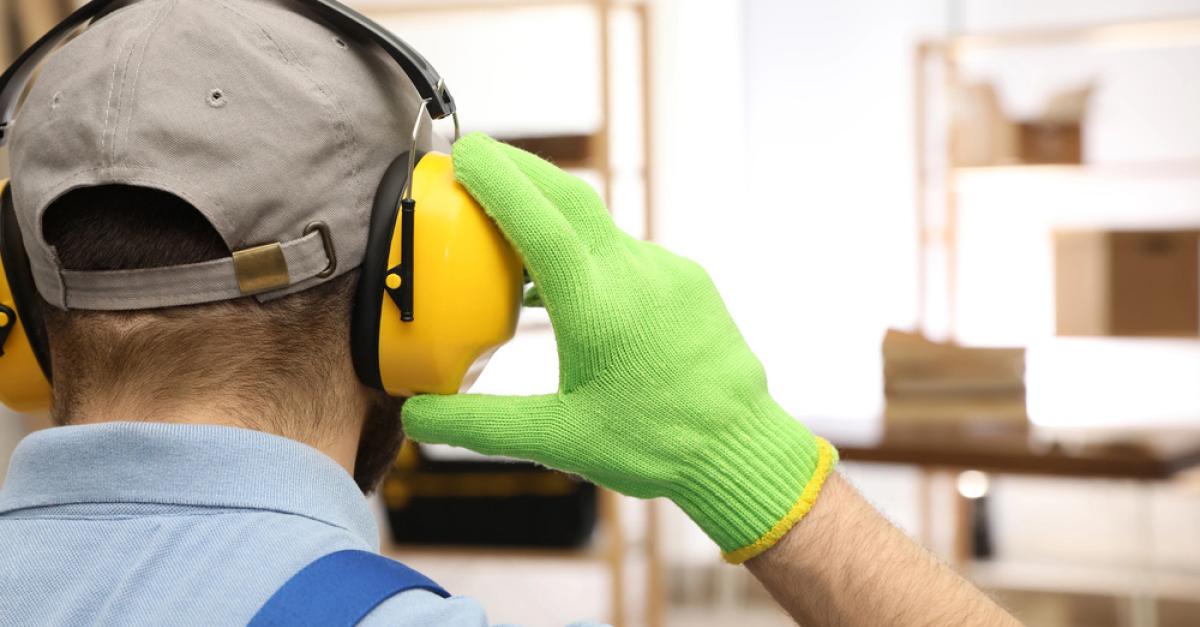 Worker adjusting safety ear protectors