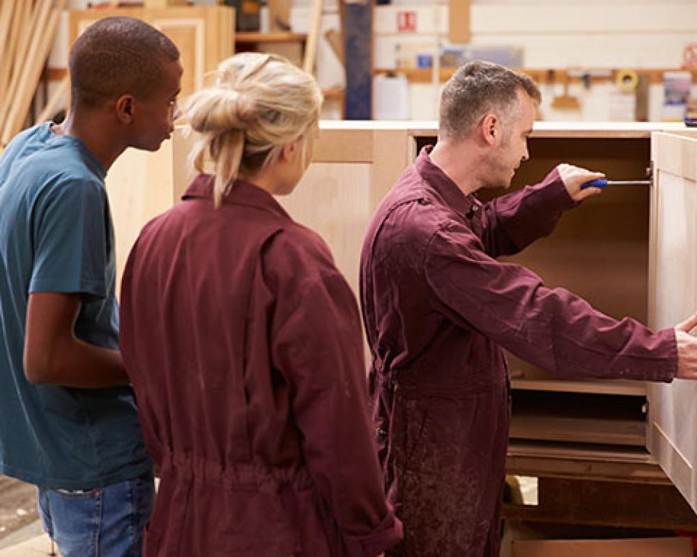 Apprentices assembling cabinet