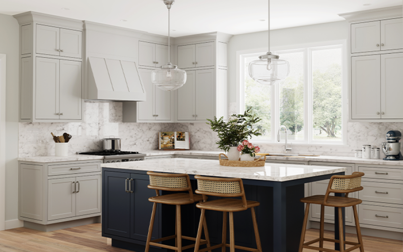 Daylight appears through a window of a kitchen featuring light cabinets, an island and stools.