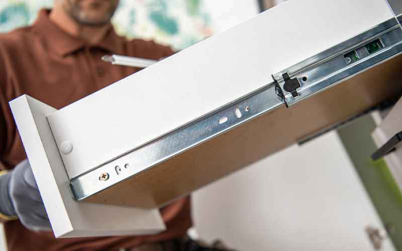 Close-up of an opened kitchen cabinet drawer being tested for certification.